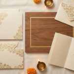 Elegant Indian wedding stationery flat lay - ornate wedding invitation cards with intricate floral gold designs, wedding…